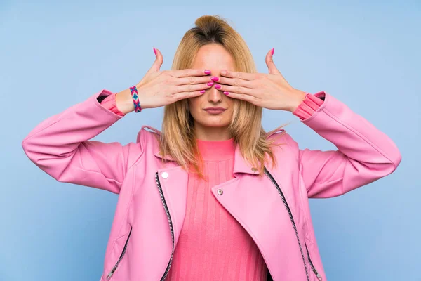 Молода Блондинка Рожевою Курткою Над Ізольованим Синім Тлом Закриває Очі — стокове фото