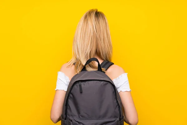 Jovem Loira Sobre Isolado Parede Amarela Com Mochila — Fotografia de Stock