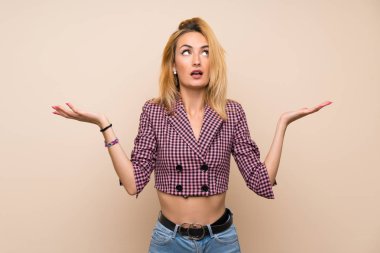 İzole duvar üzerinde pembe ceket ile genç sarışın kadın kötü bir durum tarafından hayal kırıklığına