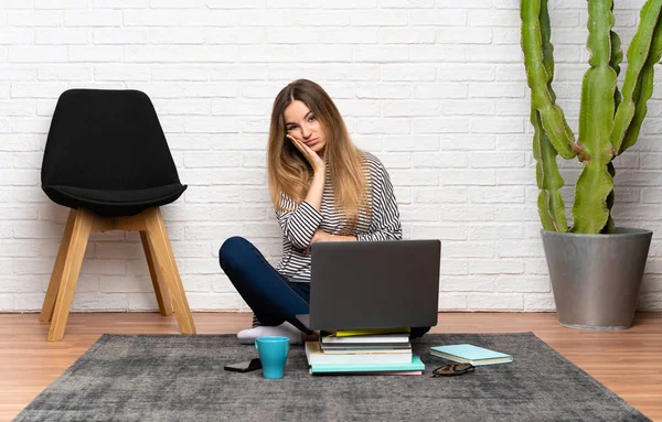 stock image Young woman sitting on the floor with her laptop unhappy and frustrated