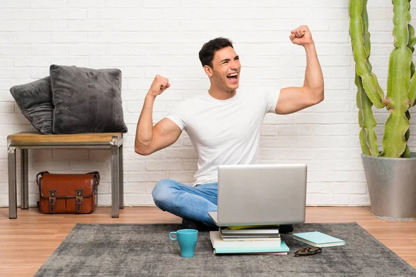 Bonito Homem Sentado Chão Com Seu Laptop Comemorando Uma Vitória — Fotografia de Stock