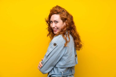 Izole sarı arka plan üzerinde Redhead kadın gülüyor
