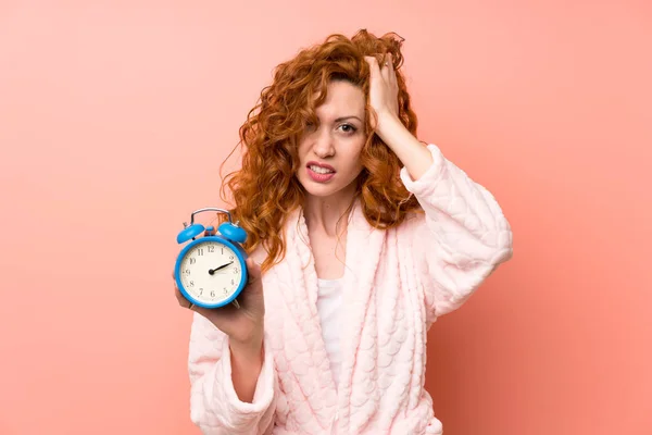 Redhead woman in dressing gown holding vintage clock — Stock Photo, Image