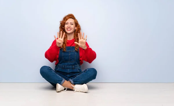 Redhead Kvinna Med Overaller Sitter Golvet Räkna Nio Med Fingrarna — Stockfoto