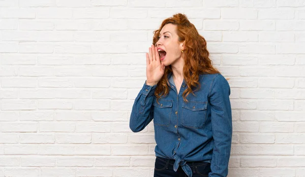 Redhead Woman White Brick Wall Shouting Mouth Wide Open Lateral — Stock Photo, Image