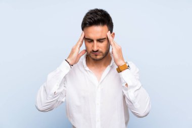 Baş ağrısı ile izole mavi arka plan üzerinde Yakışıklı genç adam