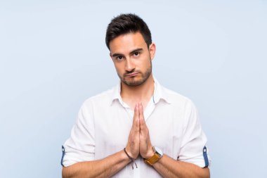 Izole mavi arka plan üzerinde Yakışıklı genç adam birlikte palmiye tutar. Kişi bir şey ister