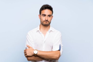 Izole mavi arka plan üzerinde Yakışıklı genç adam üzgün duygu