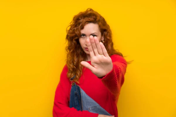 Zole Sarı Duvar Üzerinde Tulum Ile Redhead Kadın Eliyle Stop — Stok fotoğraf