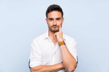 Izole mavi arka plan üzerinde Yakışıklı genç adam ön arıyorsunuz
