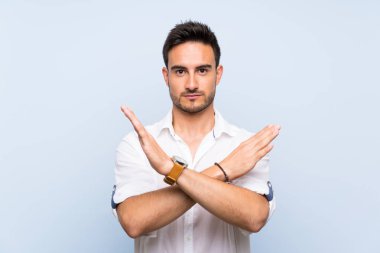 Izole mavi arka plan üzerinde Yakışıklı genç adam hiçbir jest yapma