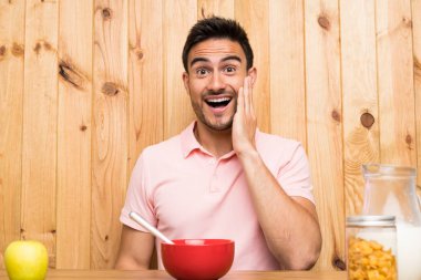 Bir mutfakta sürpriz ve şok yüz ifadesi ile kahvaltı yakışıklı genç adam
