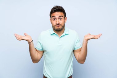 El kaldırırken şüpheleri olan izole arka plan üzerinde Yakışıklı genç adam