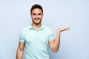 Bir reklam eklemek için avuç üzerinde copyspace hayali tutan izole arka plan üzerinde Yakışıklı genç adam