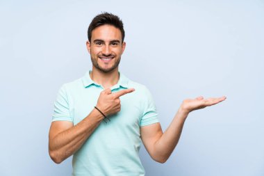 Bir reklam eklemek için avuç üzerinde copyspace hayali tutan izole arka plan üzerinde Yakışıklı genç adam