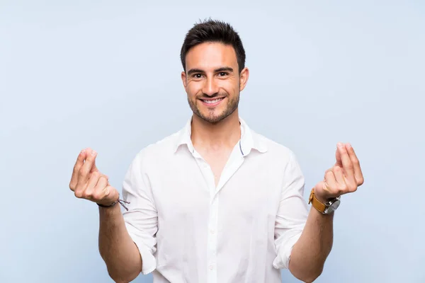 Guapo Joven Sobre Aislado Fondo Azul Haciendo Gesto Dinero — Foto de Stock