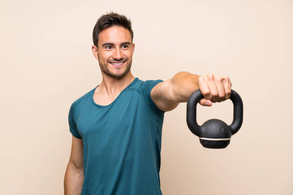 Handsome sport man over isolated background with kettlebell