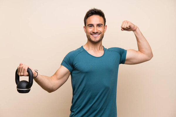 Handsome sport man over isolated background with kettlebell