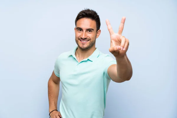 Guapo Joven Sobre Fondo Aislado Sonriendo Mostrando Señal Victoria —  Fotos de Stock