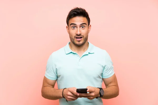 Guapo Joven Sobre Aislado Fondo Sorprendido Enviando Mensaje —  Fotos de Stock