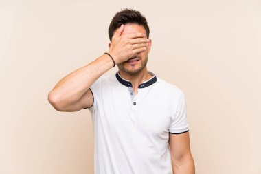 Gözleri elleriyle kaplayan izole arka plan üzerinde yakışıklı genç adam. Bir şey görmek istemiyorum