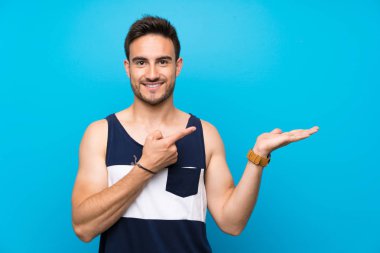 Bir reklam eklemek için avuç üzerinde copyspace hayali tutan izole arka plan üzerinde Yakışıklı genç adam