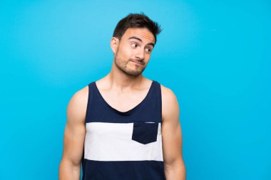 Izole arka plan üzerinde yakışıklı genç adam yan görünümlü şüpheler jest yapma