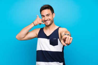 Izole arka plan üzerinde yakışıklı genç adam telefon jest yapma ve ön işaret