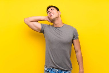 Boyun ağrısı ile izole sarı duvar üzerinde Yakışıklı adam