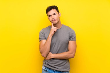 Izole sarı duvar üzerinde Yakışıklı adam ön bakıyor