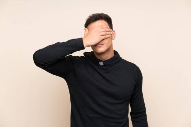 Elleriyle gözleri kaplayan izole arka plan üzerinde Yakışıklı adam