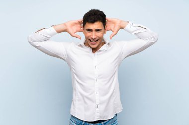 Mavi duvar üzerinde Yakışıklı adam sinirli ve kafasına el ele alır