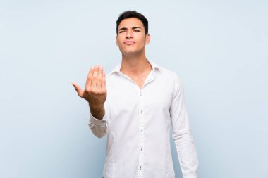 Mavi duvarın üzerinde yakışıklı bir adam el ele gelmeye davet ediyor. Geldiğin için mutluyum.