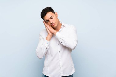 Mavi duvar üzerinde yakışıklı adam dorable ifade uyku jest yapma