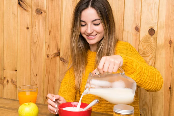 Junge Frau frühstückt in einer Küche — Stockfoto