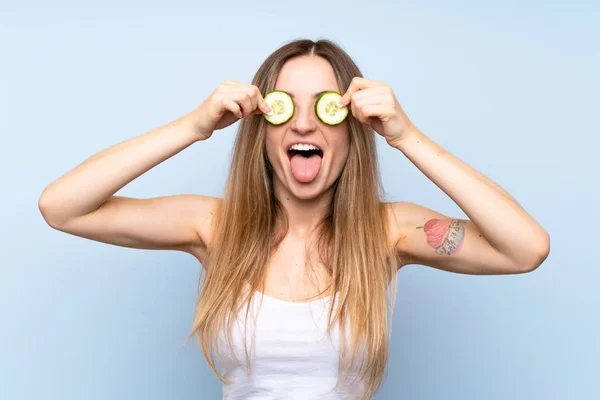 Beautiful young woman holding slices of cucumber — Stock Photo, Image