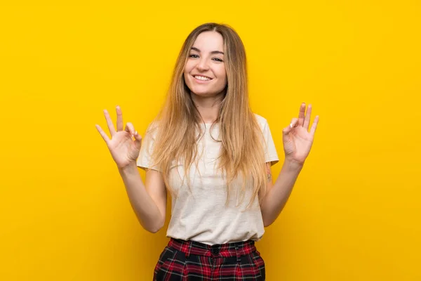 Genç Kadın Üzerinde Izole Sarı Duvar Gösteren Bir Işareti Ile — Stok fotoğraf