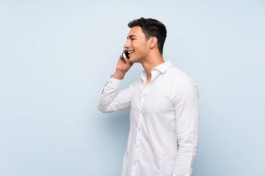 Cep telefonu ile bir konuşma tutmak mavi duvar üzerinde Yakışıklı adam