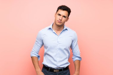 Üzgün ve depresif ifade ile pembe arka plan üzerinde Yakışıklı adam