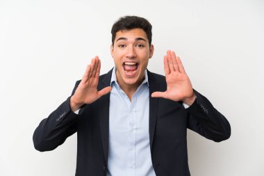 Yakışıklı adam üzerinde izole beyaz duvar bağırmak ile ağız geniş açık