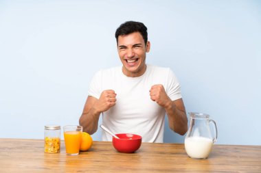 Bir zafer kutluyor kahvaltı sahip yakışıklı adam