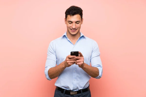 Knappe Man Roze Achtergrond Verzenden Van Een Bericht Met Mobiele — Stockfoto