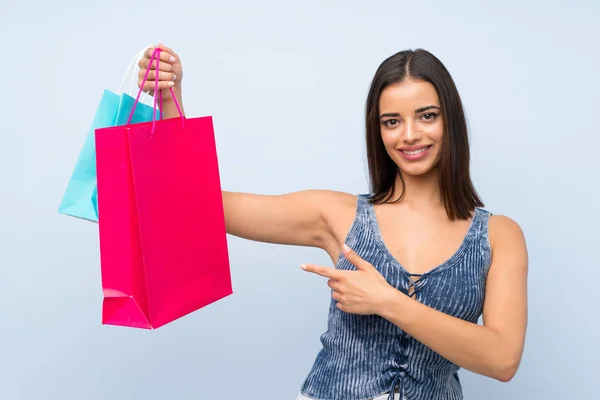 Jonge Vrouw Geïsoleerde Blauwe Muur Houden Veel Boodschappentassen — Stockfoto