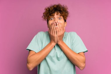 Sürpriz yüz ifadesi ile izole mor duvar üzerinde genç afro-amerikan adam