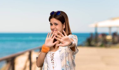 Yaz tatillerinde bikinili genç kadın, plajda önden el germe gergin