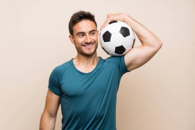 Bir futbol topu tutan izole arka plan üzerinde yakışıklı spor adam