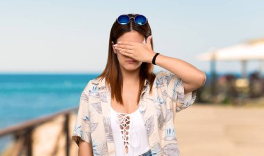 Yaz tatillerinde bikinili genç kadın gözleri elleriyle kaplayan. Sahilde bir şey görmek istemiyorum