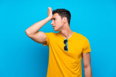 Mavi arka plan üzerinde Yakışıklı adam bir şey fark etti ve çözüm niyetinde