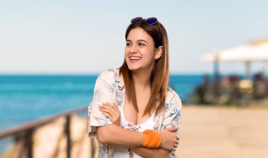 Plajda gülümseyen iken yaz tatillerinde Bikini genç kadın bakıyor