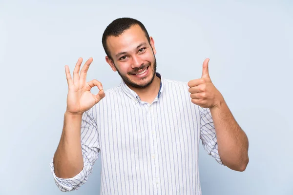Kolumbijski Człowiek Białym Tle Niebieską Ścianę Pokazując Znak Kciuka Górę — Zdjęcie stockowe